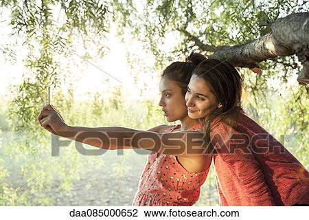 Girlfriends posing for selfie View Large Photo Image Stock Image - Girlfriends posing for selfie. Fotosearch