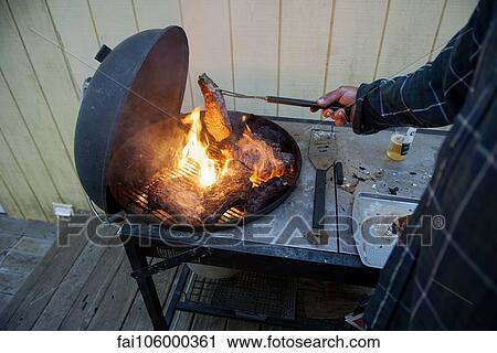 Stock Image - Grilling steaks. Fotosearch