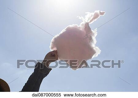 Hand holding cotton candy against blue sky View Large Photo Image Stock Photography - Hand holding cotton candy against blue sky. Fotosearch