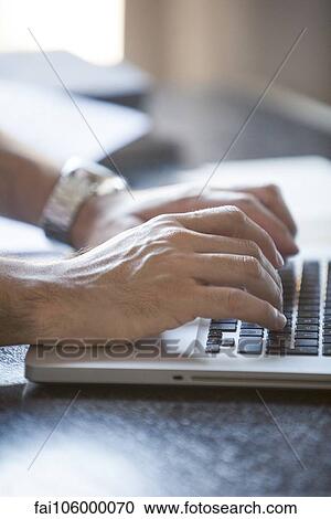 Stock Image - Hands typing on laptop computer keyboard. Fotosearch