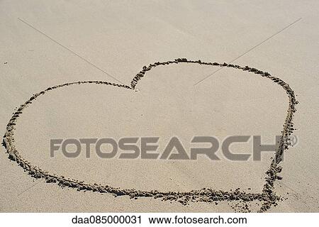 Stock Image - Heart drawn in sand on beach. Fotosearch