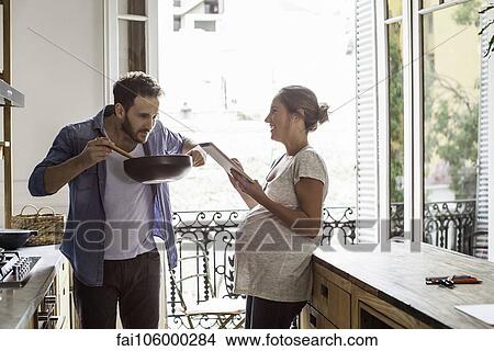 Picture - Husband and wife cooking at home. Fotosearch