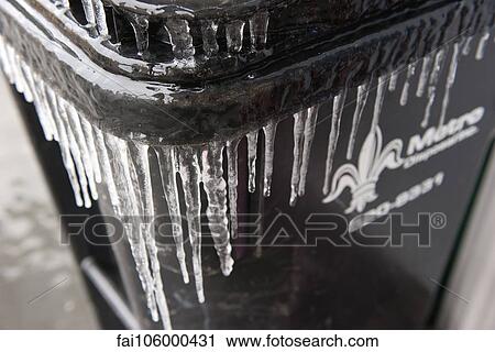 Stock Image - Icicles hanging on garbage can. Fotosearch