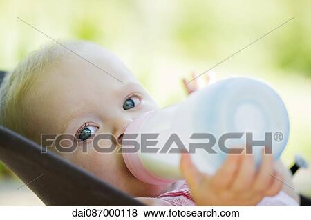 Infant drinking milk from bottle View Large Photo Image Stock Photo - Infant drinking milk from bottle. Fotosearch