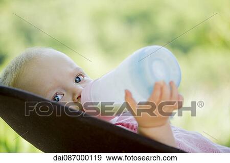 Infant drinking milk from bottle View Large Photo Image Stock Photo - Infant drinking milk from bottle. Fotosearch