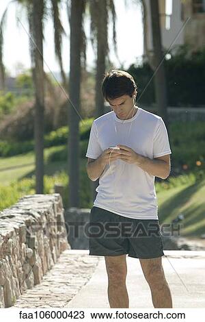 Jogger checking smartphone in park View Large Photo Image Stock Image - Jogger checking smartphone in park. Fotosearch