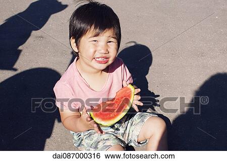 Stock Photograph - Little boy eating watermelon, portrait. Fotosearch