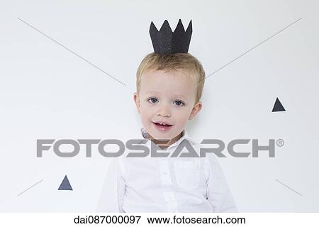Stock Photo - Little boy wearing paper crown, portrait. Fotosearch