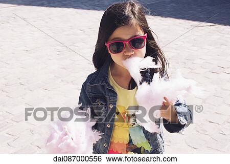 Little girl eating cotton candy View Large Photo Image Stock Photograph - Little girl eating cotton candy. Fotosearch