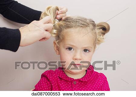 Little girl having her hair arranged in pigtails View Large Photo Image Stock Image - Little girl having her hair arranged in pigtails. Fotosearch