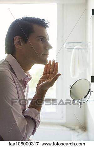 Man applying moisturizer to face View Large Photo Image Stock Photo - Man applying moisturizer to face. Fotosearch