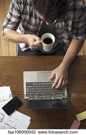 Man at desk using laptop View Large Photo Image Stock Image - Man at desk using laptop. Fotosearch