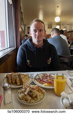 Man eating breakfast in diner View Large Photo Image Stock Image - Man eating breakfast in diner. Fotosearch