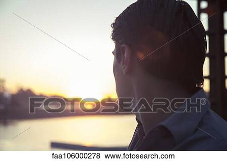 Stock Photo - Man looking at sunset. Fotosearch