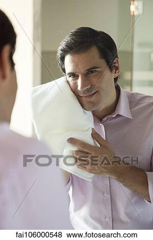 Man looking in mirror, drying his face with a towel View Large Photo Image Stock Photo - Man looking in mirror, drying his face with a towel. Fotosearch