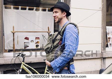 Man out and about in the city with baby in carrier View Large Photo Image Picture - Man out and about in the city with baby in carrier. Fotosearch