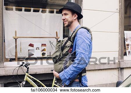 Man out and about in the city with baby in carrier View Large Photo Image Picture - Man out and about in the city with baby in carrier. Fotosearch