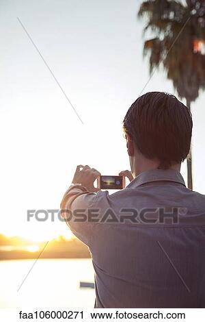 Man photographing sunset with smartphone View Large Photo Image Stock Image - Man photographing sunset with smartphone. Fotosearch