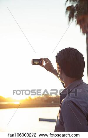 Man photographing sunset with smartphone View Large Photo Image Stock Image - Man photographing sunset with smartphone. Fotosearch
