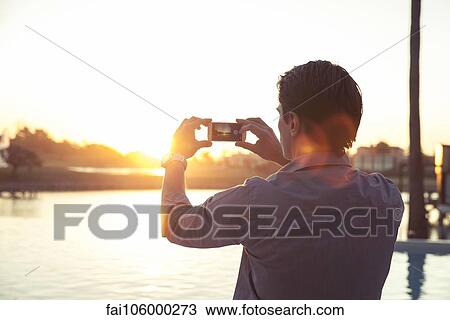 Man photographing sunset with smartphone View Large Photo Image Stock Image - Man photographing sunset with smartphone. Fotosearch