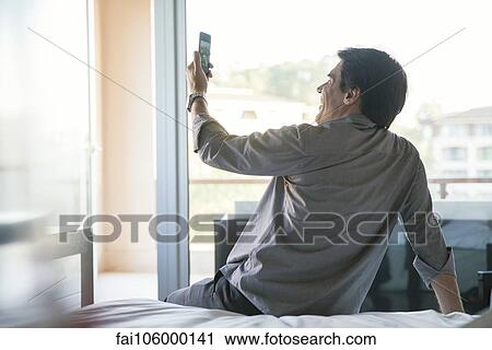 Man posing for a selfie on bed View Large Photo Image Stock Image - Man posing for a selfie on bed. Fotosearch