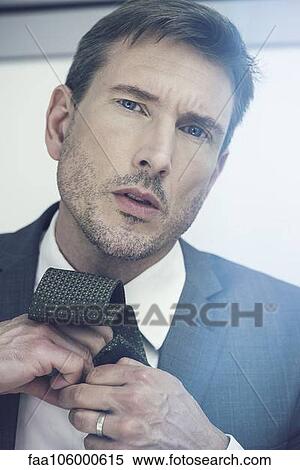 Man putting on necktie View Large Photo Image Stock Photography - Man putting on necktie. Fotosearch