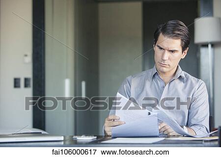 Man reading document in office View Large Photo Image Stock Photo - Man reading document in office. Fotosearch