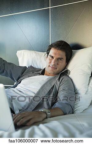 Man relaxing on bed, portrait View Large Photo Image Stock Photo - Man relaxing on bed, portrait. Fotosearch
