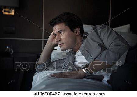 Man relaxing on bed View Large Photo Image Stock Photo - Man relaxing on bed. Fotosearch