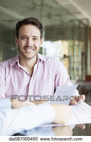 Man reviewing documents with financial advisor View Large Photo Image Stock Image - Man reviewing documents with financial advisor. Fotosearch