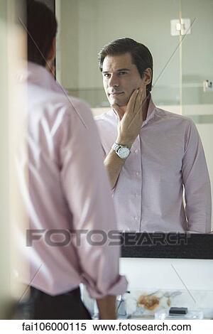 Man scrutinizing himself in mirror View Large Photo Image Stock Photography - Man scrutinizing himself in mirror. Fotosearch