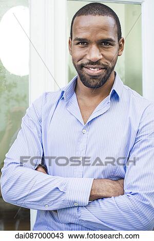 Man smiling with arms folded across chest, portrait View Large Photo Image Stock Image - Man smiling with arms folded across chest, portrait. Fotosearch