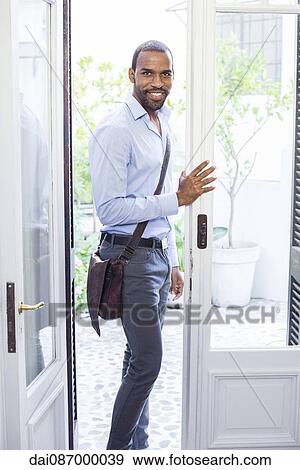 Man standing in open doorway, smiling, portrait View Large Photo Image Stock Photo - Man standing in open doorway, smiling, portrait. Fotosearch