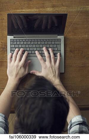 Stock Photo - Man typing furiously on laptop computer. Fotosearch