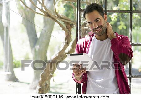 Man using digital tablet at home View Large Photo Image Stock Photograph - Man using digital tablet at home. Fotosearch