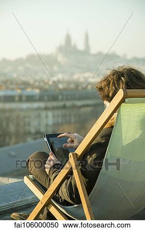 Man using digital tablet on rooftop terrace View Large Photo Image Stock Image - Man using digital tablet on rooftop terrace. Fotosearch