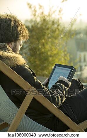 Man using digital tablet outdoors View Large Photo Image Stock Photo - Man using digital tablet outdoors. Fotosearch