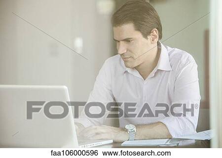 Man using laptop computer in office View Large Photo Image Stock Photograph - Man using laptop computer in office. Fotosearch