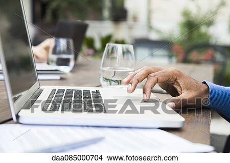 Picture - Man using laptop computer touchpad. Fotosearch