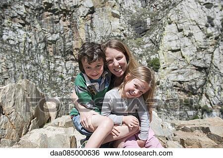 Mother and children sitting on rock formation, portrait View Large Photo Image Stock Photograph - Mother and children sitting on rock formation, portrait. Fotosearch