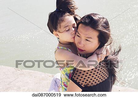 Stock Photo - Mother and young daughter embracing outdoors. Fotosearch