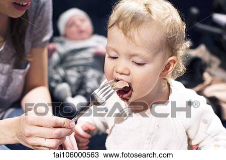 Stock Image - Mother feeding toddler. Fotosearch