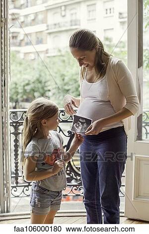 Mother preparing daughter for arrival of her new sibling View Large Photo Image Stock Image - Mother preparing daughter for arrival of her new sibling. Fotosearch