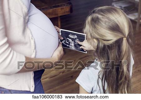 Mother showing daughter ultrasound photo View Large Photo Image Stock Image - Mother showing daughter ultrasound photo. Fotosearch