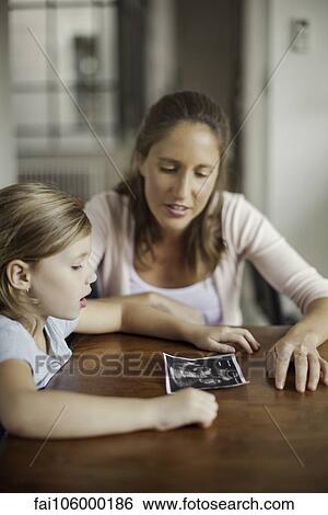 Stock Photograph - Mother showing daughter ultrasound photo. Fotosearch