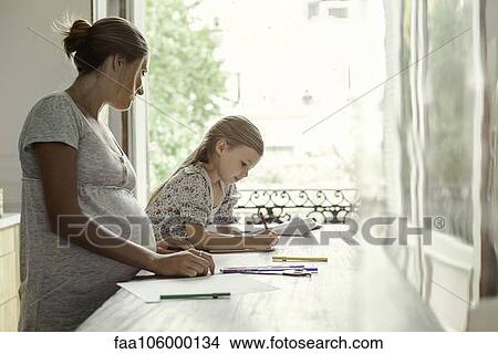 Mother watching daughter coloring View Large Photo Image Picture - Mother watching daughter coloring. Fotosearch