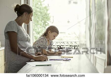 Mother watching daughter coloring View Large Photo Image Picture - Mother watching daughter coloring. Fotosearch