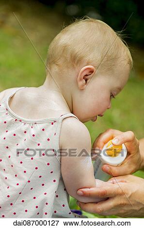Parent spraying sunscreen on baby's arm View Large Photo Image Stock Photo - Parent spraying sunscreen on baby's arm. Fotosearch