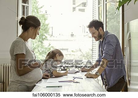 Parents watching as daughter colors View Large Photo Image Stock Photography - Parents watching as daughter colors. Fotosearch