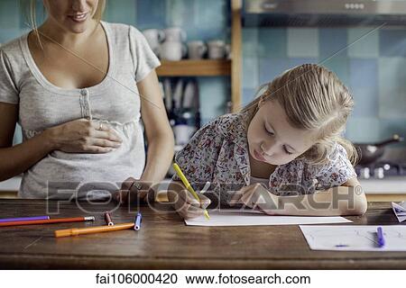 Pregnant mother looking on as daughter draws View Large Photo Image Stock Image - Pregnant mother looking on as daughter draws. Fotosearch